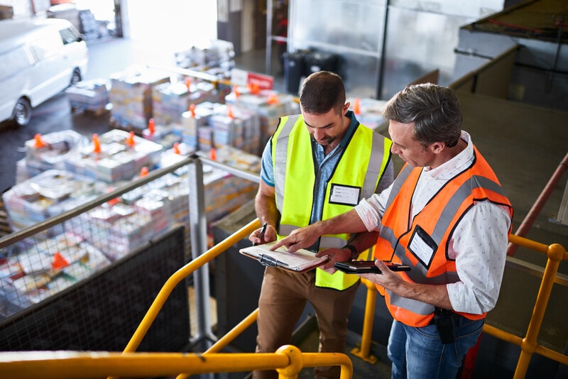 Workers in a warehouse checking documents