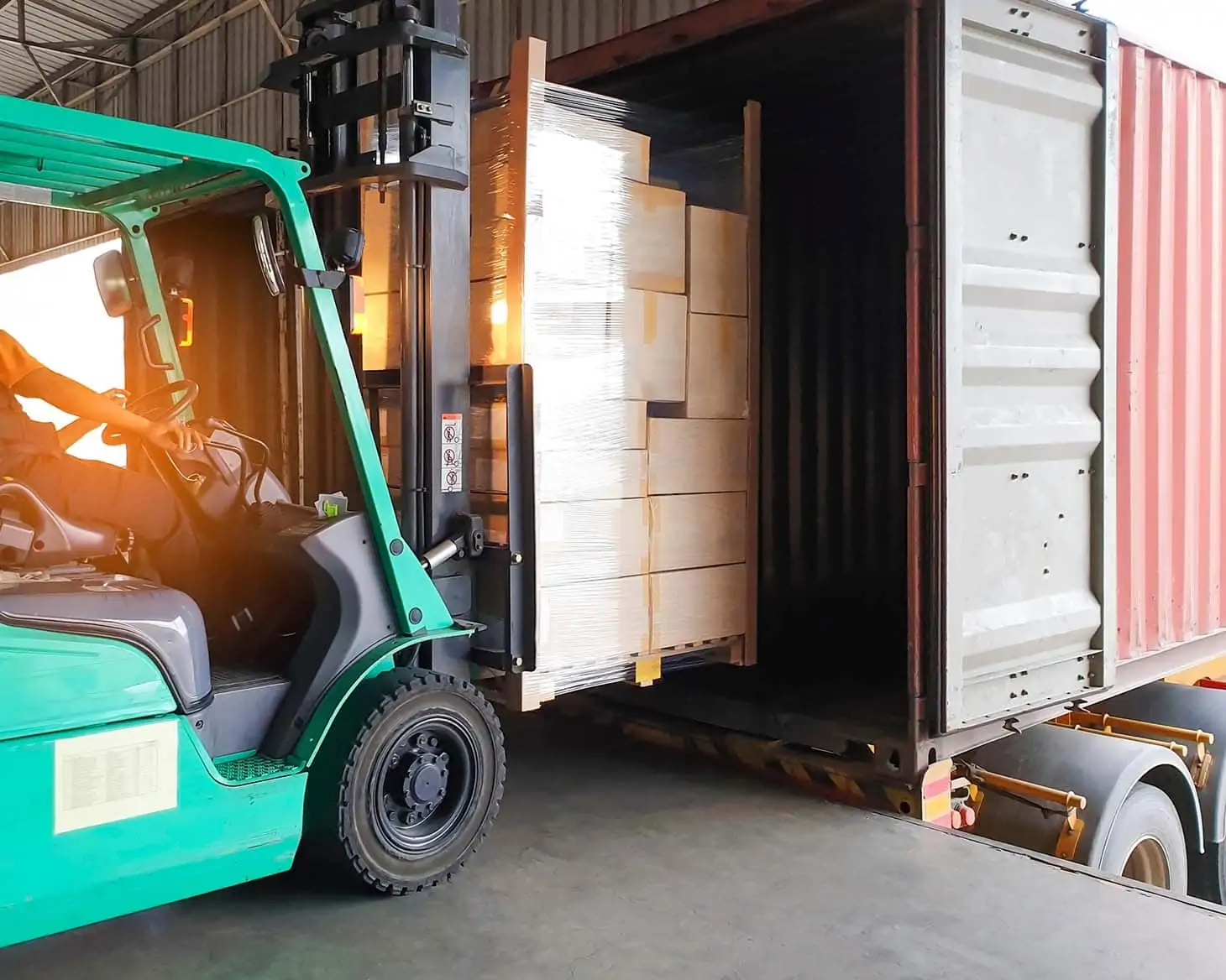 Sea freight being leaded into a container at the warehouse by a forklift
