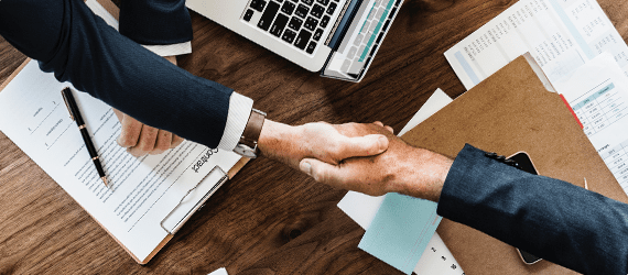 Business people shaking hands over a desk
